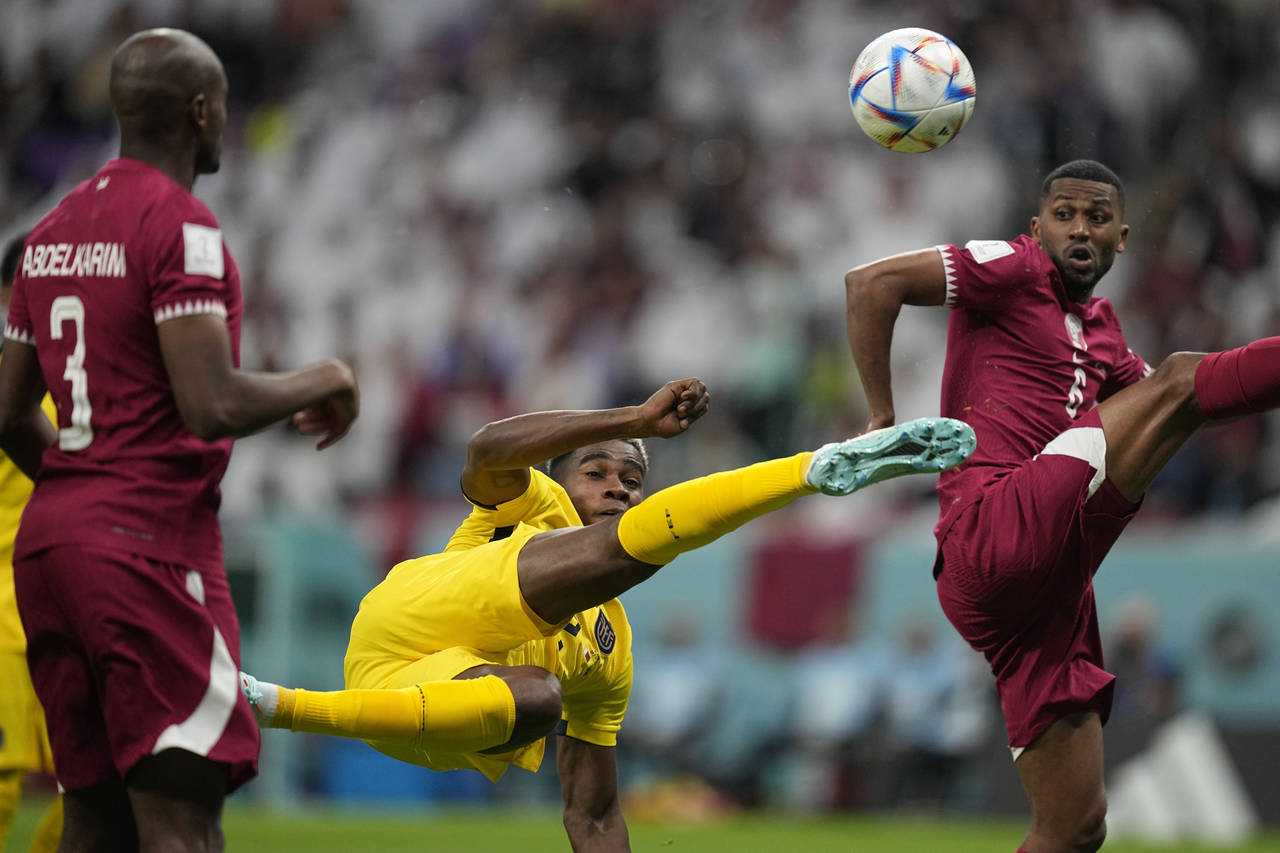 Ecuador's Felix Torres, center, duels for the ball with Qatar's Abdulaziz Hatem, right, during the ...