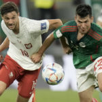 
              FILE - Poland's Bartosz Bereszynski, left, and Mexico's Hirving Lozano battle for the ball during the World Cup group C soccer match between Mexico and Poland, at the Stadium 974 in Doha, Qatar, Tuesday, Nov. 22, 2022. (AP Photo/Moises Castillo, File)
            