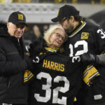 
              Pittsburgh Steelers owner Art Rooney II, left, and Franco Harris' widow Dana, center, and son Dok, attend a ceremony to retire Harris' No. 32 jersey at half-time of an NFL football game against the Las Vegas Raiders, Saturday, Dec. 24, 2022. Harris, a four-time Super Bowl champion, passed away Dec. 21, 2022, at the age of 72. (AP Photo/Don Wright)
            