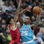 
              Charlotte Hornets forward P.J. Washington, right, shoots over Portland Trail Blazers guard Anfernee Simons during the first half of an NBA basketball game in Portland, Ore., Monday, Dec. 26, 2022. (AP Photo/Craig Mitchelldyer)
            