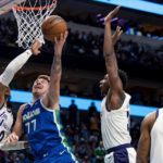 
              Dallas Mavericks guard Luka Doncic (77) goes up for a shot while Los Angeles Lakers guard Russell Westbrook (0) and Los Angeles Lakers center Thomas Bryant defend him in the second half of an NBA basketball game in Dallas, Sunday, Dec. 25, 2022. (AP Photo/Emil T. Lippe)
            