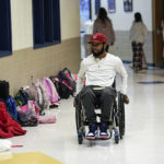 
              Former Southern University football player Devon Gales moves through the halls at Jefferson Academy Friday, Dec. 16, 2022, in Jefferson, Ga. Gales, who suffered a spinal cord injury and left paralyzed during a game against Georgia in 2015, works at the school while finishing his college degree at Georgia. (AP Photo/John Bazemore )
            