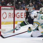 
              San Jose Sharks' Alexander Barabanov (94) misses the net on a shot attempt against Vancouver Canucks goalie Spencer Martin (30) during the second period of an NHL hockey game Tuesday, Dec. 27, 2022, in Vancouver, British Columbia. (Darryl Dyck/The Canadian Press via AP)
            