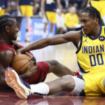 
              Indiana Pacers guard Bennedict Mathurin (00) and Cleveland Cavaliers guard Caris LeVert (3) battle for a loose ball during the first half of an NBA basketball game, Friday, Dec. 16, 2022, in Cleveland. (AP Photo/Ron Schwane)
            