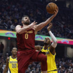 
              Cleveland Cavaliers forward Kevin Love (0) shoots against Indiana Pacers center Myles Turner and guard Bennedict Mathurin (00) during the first half of an NBA basketball game, Friday, Dec. 16, 2022, in Cleveland. (AP Photo/Ron Schwane)
            