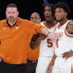 
              Texas' head coach Chris Beard, left, meets with Tyrese Hunter (4) and Marcus Carr (5) at the bench during the first half of the team's NCAA college basketball game against Illinois in the Jimmy V Classic, Tuesday, Dec. 6, 2022, in New York. (AP Photo/John Minchillo)
            