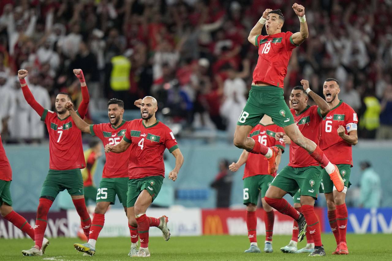 Morocco's Jawad El Yamiq, top, celebrates with team mates after the penalty shootout at the World C...