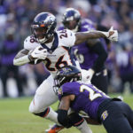 
              Denver Broncos running back Mike Boone (26) comes under pressure from Baltimore Ravens safety Geno Stone (26) as he carries the ball in the second half of an NFL football game, Sunday, Dec. 4, 2022, in Baltimore. (AP Photo/Patrick Semansky)
            