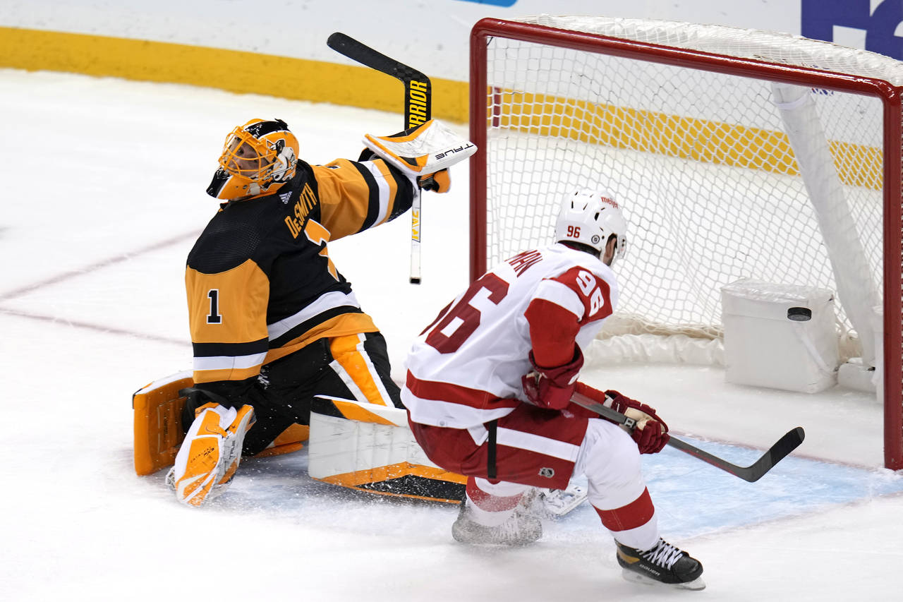 Detroit Red Wings' Jake Walman backhands a shot past Pittsburgh Penguins goaltender Casey DeSmith f...