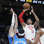 
              Philadelphia 76ers forward Tobias Harris (12) shoots in front of Oklahoma City Thunder center Mike Muscala, left, guard Shai Gilgeous-Alexander, center, and teammate De'Anthony Melton (8), in the first half of an NBA basketball game Saturday, Dec. 31, 2022, in Oklahoma City. (AP Photo/Sue Ogrocki)
            