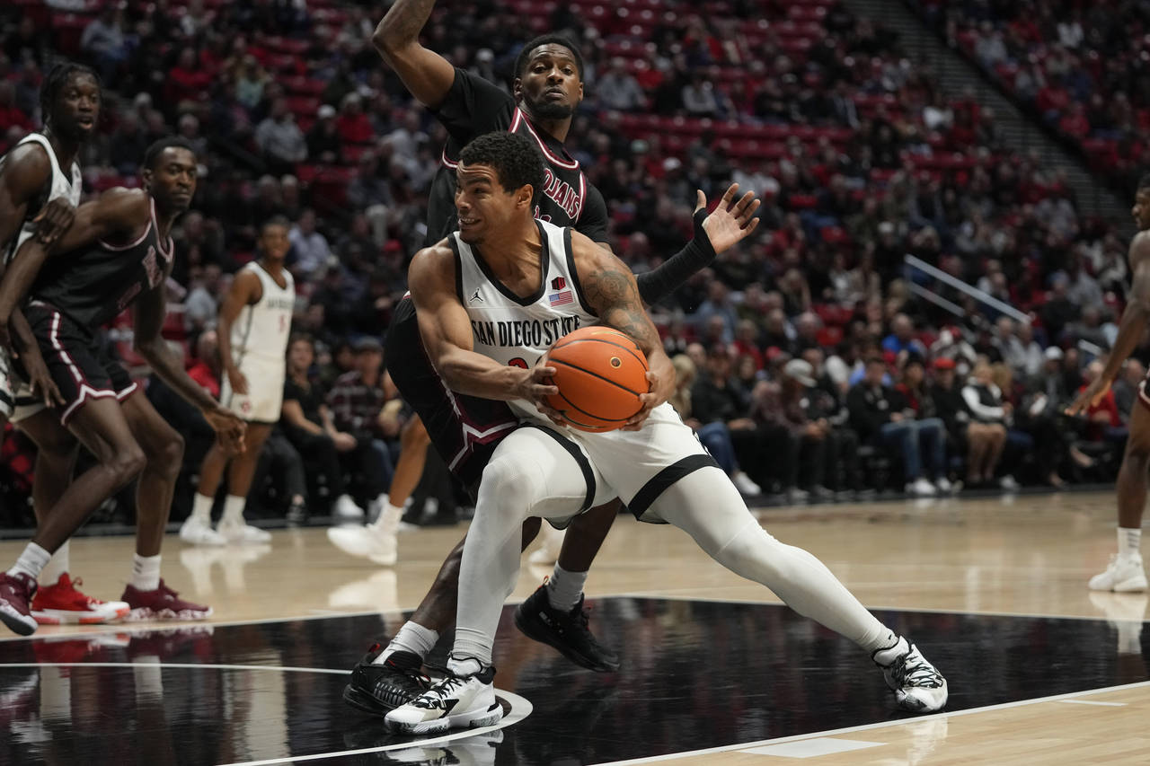 San Diego State guard Matt Bradley, below, drives with the ball as Troy guard Nelson Phillips defen...