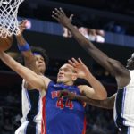 
              Detroit Pistons forward Bojan Bogdanovic (44) goes to the basket against Orlando Magic forward Paolo Banchero, left, and center Bol Bol (10) during the first half of an NBA basketball game Wednesday, Dec. 28, 2022, in Detroit. (AP Photo/Duane Burleson)
            