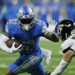 
              Detroit Lions running back D'Andre Swift rushes past Jacksonville Jaguars safety Andrew Wingard (42) during the second half of an NFL football game, Sunday, Dec. 4, 2022, in Detroit. (AP Photo/Duane Burleson)
            