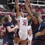 
              Stanford guard Haley Jones (30) shoots against Gonzaga's Brynna Maxwell, left, and Yvonne Ejim, right, during the first half of an NCAA college basketball game in Stanford, Calif., Sunday, Dec. 4, 2022. (AP Photo/Tony Avelar)
            