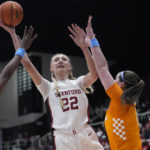 
              Stanford forward Cameron Brink (22) shoots between Tennessee guard Jordan Horston, left, and forward Sara Puckett, right, during the first half of an NCAA college basketball game in Stanford, Calif., Sunday, Dec. 18, 2022. (AP Photo/Godofredo A. Vásquez)
            