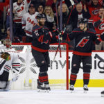 
              Carolina Hurricanes' Jesper Fast, second right, is congratulated on his goal by Hurricanes' Jordan Martinook (48), and Jordan Staal (11) with Chicago Blackhawks goaltender Petr Mrazek (34) and Connor Murphy (5) nearby and during the first period of an NHL hockey game in Raleigh, N.C., Tuesday, Dec. 27, 2022. (AP Photo/Karl B DeBlaker)
            