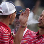 
              FILE - Xander Schauffele blows smoke toward Jordan Spieth after the USA team defeated the International team in a singles match at the Presidents Cup golf tournament at the Quail Hollow Club, Sunday, Sept. 25, 2022, in Charlotte, N.C. Schauffele ended three years without winning by winning three times this year. (AP Photo/Chris Carlson, File)
            