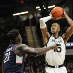 
              Butler center Manny Bates, right, shoots over Connecticut forward Adama Sanogo in the first half of an NCAA college basketball game in Indianapolis, Saturday, Dec. 17, 2022. (AP Photo/AJ Mast)
            