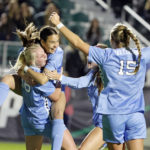 
              North Carolina's Aleigh Gambone (16) is congratulated on her goal against Florida State by Tori Dellaperuta, as teammates gather during the first half of an NCAA women's soccer tournament semifinal in Cary, N.C., Friday, Dec. 2, 2022. (AP Photo/Karl B DeBlaker)
            