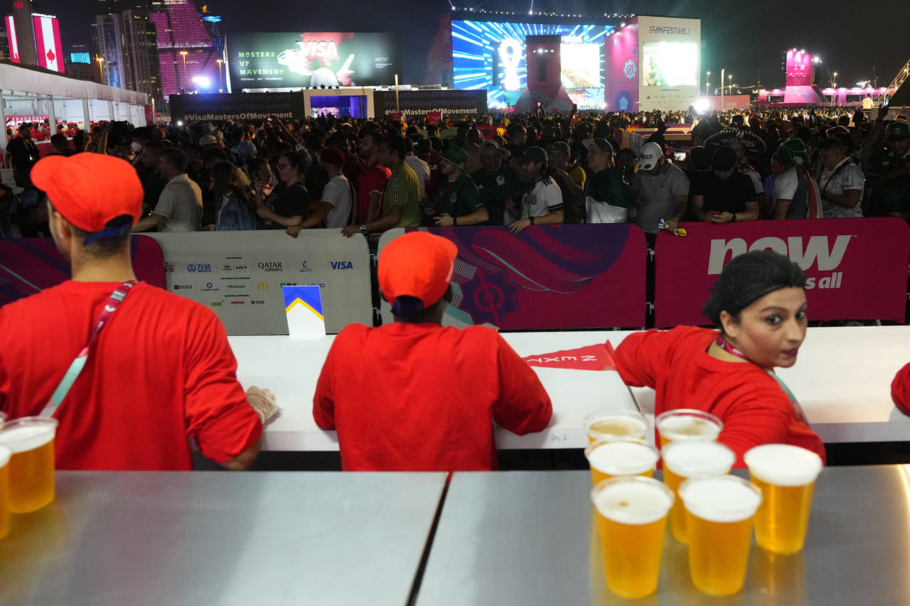 FILE - Fans wait in line for beer at a fan zone ahead of the FIFA World Cup, in Doha, Qatar Saturda...