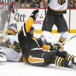 
              Pittsburgh Penguins' Jeff Carter, center, collides with Vegas Golden Knights goaltender Logan Thompson, left, during the second period of an NHL hockey game in Pittsburgh, Thursday, Dec. 1, 2022. (AP Photo/Gene J. Puskar)
            