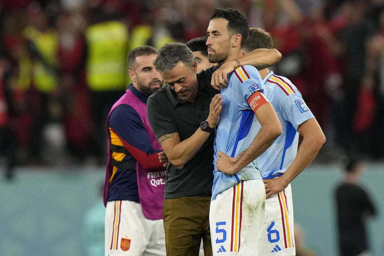 Spain's head coach Luis Enrique, left, embraces Sergio Busquets after the penalty shootout at the W...