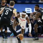 
              Detroit Pistons center Jalen Duren (0) chases a loose ball against Los Angeles Clippers guards Luke Kennard (5) and John Wall (11) during the first half of an NBA basketball game, Monday, Dec. 26, 2022, in Detroit. (AP Photo/Duane Burleson)
            