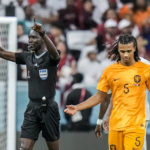 
              Referee Bakary Gassama gestures before consulting the VAR next to Nathan Ake of the Netherlands during the World Cup group A soccer match between the Netherlands and Qatar, at the Al Bayt Stadium in Al Khor , Qatar, Tuesday, Nov. 29, 2022. (AP Photo/Moises Castillo)
            