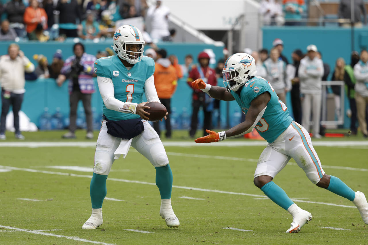 Miami Dolphins quarterback Tua Tagovailoa (1) handsoff the ball to Miami Dolphins running back Jeff...