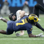 
              Purdue wide receiver Charlie Jones is stopped by Michigan defensive back Makari Paige (7) during the first half of the Big Ten championship NCAA college football game, Saturday, Dec. 3, 2022, in Indianapolis. (AP Photo/AJ Mast)
            