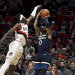 
              Minnesota Timberwolves guard D'Angelo Russell, right, shoots the ball over Portland Trail Blazers forward Jerami Grant during the first half of an NBA basketball game in Portland, Ore., Monday, Dec. 12, 2022. (AP Photo/Steve Dykes)
            