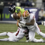 
              Seattle Seahawks running back Travis Homer (25) fumbles while being hit by San Francisco 49ers linebacker Dre Greenlaw, right, and cornerback Jimmie Ward (1) during the first half of an NFL football game in Seattle, Thursday, Dec. 15, 2022. The 49ers recovered the ball. (AP Photo/Stephen Brashear)
            