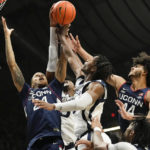 
              Connecticut's Jordan Hawkins, left, and Andre Jackson Jr., right, battle for a rebound with Butler guard Eric Hunter Jr., front center, in the second half of an NCAA college basketball game in Indianapolis, Saturday, Dec. 17, 2022. (AP Photo/AJ Mast)
            