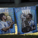 
              Flags featuring Maradona, left, and Messi, hang where Argentina soccer fans watch their team's World Cup semifinal match against Croatia, hosted by Qatar, on a screen set up in the Palermo neighborhood of Buenos Aires, Argentina, Tuesday, Dec.13, 2022. (AP Photo/Rodrigo Abd)
            