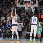
              Dallas Mavericks' Luka Doncic (77) shoots a free throw in the closing seconds of the team's NBA basketball game against the San Antonio Spurs, Saturday, Dec. 31, 2022, in San Antonio. The Mavericks won 126-125. (AP Photo/Darren Abate)
            