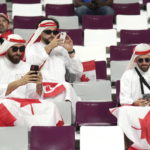 
              FILE - Canadian fans cheer ahead of F World Cup soccer action between Canada and Croatia at the Khalifa International Stadium in Al Rayyan, Qatar on Sunday, Nov. 27, 2022.  At a World Cup that has become a political lightning rod, it comes as no surprise that soccer fans’ sartorial style has sparked controversy. At the first World Cup in the Middle East, fans from around the world have refashioned traditional Gulf Arab headdresses and thobes. (Nathan Denette/The Canadian Press via AP, File)
            