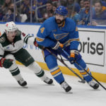 
              St. Louis Blues' Nick Leddy (4) looks to pass as Minnesota Wild's Calen Addison (2) defends during the second period of an NHL hockey game Saturday, Dec. 31, 2022, in St. Louis. (AP Photo/Jeff Roberson)
            