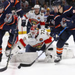 
              Florida Panthers goalie Sergei Bobrovsky (72) reaches for the puck between New York Islanders defenseman Scott Mayfield, left, and center Jean-Gabriel Pageau during the second period of an NHL hockey game Friday, Dec. 23, 2022, in Elmont, N.Y. (AP Photo/John Munson)
            
