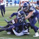 
              Tennessee Titans quarterback Malik Willis (7) is pushed over the goal line by guard Jordan Roos (70) as he is tackled by Houston Texans defensive tackle Maliek Collins, bottom, during an NFL football game Saturday, Dec. 24, 2022, in Nashville, Tenn. (AP Photo/Wade Payne)
            