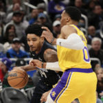 
              Orlando Magic guard Gary Harris (14) drives against Los Angeles Lakers guard Russell Westbrook (0) during the first half of an NBA basketball game, Tuesday, Dec. 27, 2022, in Orlando, Fla. (AP Photo/Kevin Kolczynski)
            