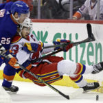 
              New Jersey Devils center Nico Hischier (13) is knocked to the ice by New York Islanders defenseman Sebastian Aho (25) during the first period of an NHL hockey game Friday, Dec. 9, 2022, in Newark, N.J. (AP Photo/Adam Hunger)
            