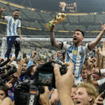 
              Argentina's Lionel Messi celebrates with the trophy in front of the fans after winning the World Cup final soccer match between Argentina and France at the Lusail Stadium in Lusail, Qatar, Sunday, Dec. 18, 2022. Argentina won 4-2 in a penalty shootout after the match ended tied 3-3. (AP Photo/Martin Meissner)
            