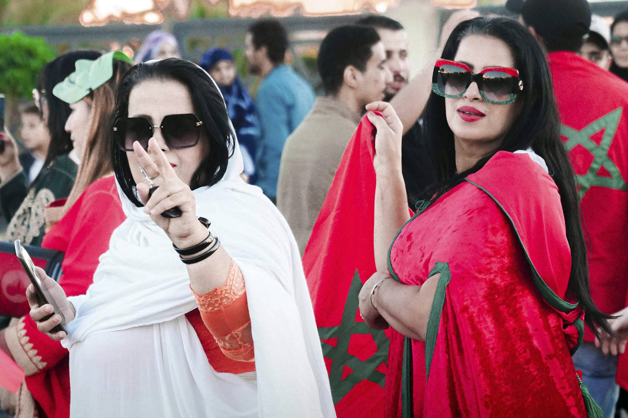 Women wearing a Sahrawis traditional outfit celebrate Morocco's World Cup victory against Portugal ...