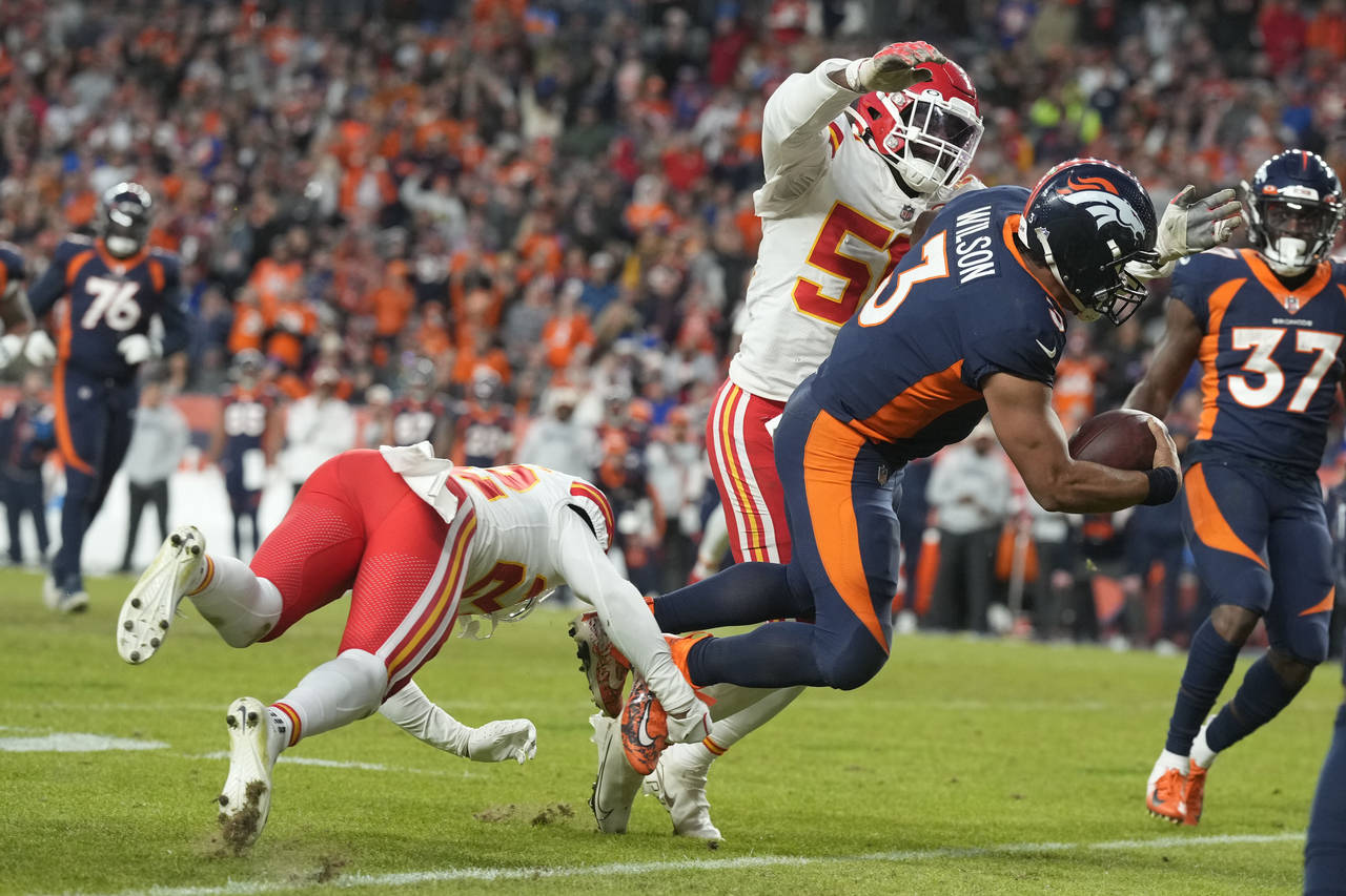 Denver Broncos quarterback Russell Wilson, right, goes down as he is tackled by Kansas City Chiefs ...