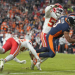 
              Denver Broncos quarterback Russell Wilson, right, goes down as he is tackled by Kansas City Chiefs defensive end Mike Danna (51) and safety Juan Thornhill (22) during the second half of an NFL football game Sunday, Dec. 11, 2022, in Denver. (AP Photo/David Zalubowski)
            
