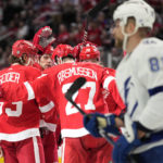 
              Teammates celebrate with Detroit Red Wings center Michael Rasmussen (27) after his goal during the first period of an NHL hockey game against the Tampa Bay Lightning, Wednesday, Dec. 21, 2022, in Detroit. (AP Photo/Carlos Osorio)
            