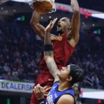 
              Cleveland Cavaliers forward Evan Mobley, top, dunks against Orlando Magic forward Paolo Banchero, bottom, during the first half of an NBA basketball game, Friday, Dec. 2, 2022, in Cleveland. (AP Photo/Ron Schwane)
            