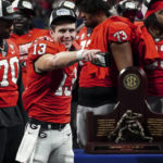 
              Georgia quarterback Stetson Bennett (13) gestures to the crowd during the trophy presentation the Southeastern Conference Championship football game Saturday, Dec. 3, 2022 in Atlanta. (AP Photo/John Bazemore)
            