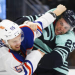 
              Edmonton Oilers left wing Dylan Holloway (55) and Seattle Kraken defenseman Vince Dunn (29) fight during the second period of an NHL hockey game Friday, Dec. 30, 2022, in Seattle. (AP Photo/Lindsey Wasson)
            