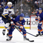 
              New York Islanders left wing Anders Lee (27) clears the puck in front of St. Louis Blues center Ivan Barbashev during the second period of an NHL hockey game Tuesday, Dec. 6, 2022, in Elmont, N.Y. (AP Photo/Adam Hunger)
            